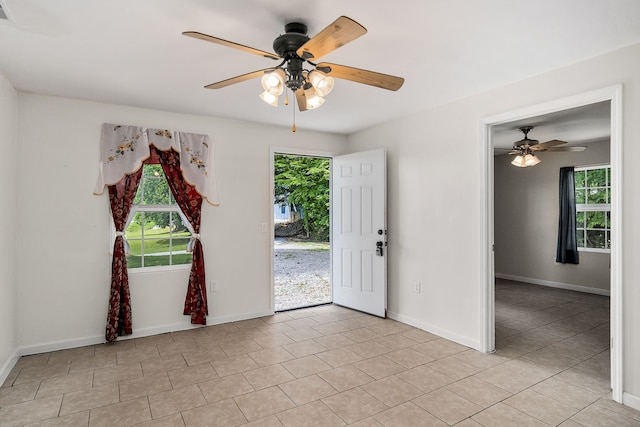 unfurnished room with ceiling fan and light tile floors