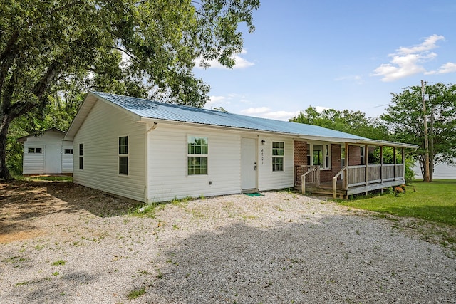 view of front of property with an outdoor structure, a porch, and a front yard