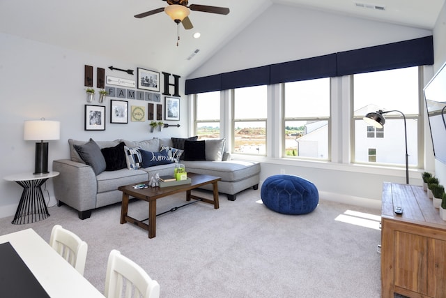 carpeted living room with ceiling fan and high vaulted ceiling