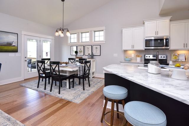 dining room featuring a notable chandelier, light wood-type flooring, and a wealth of natural light