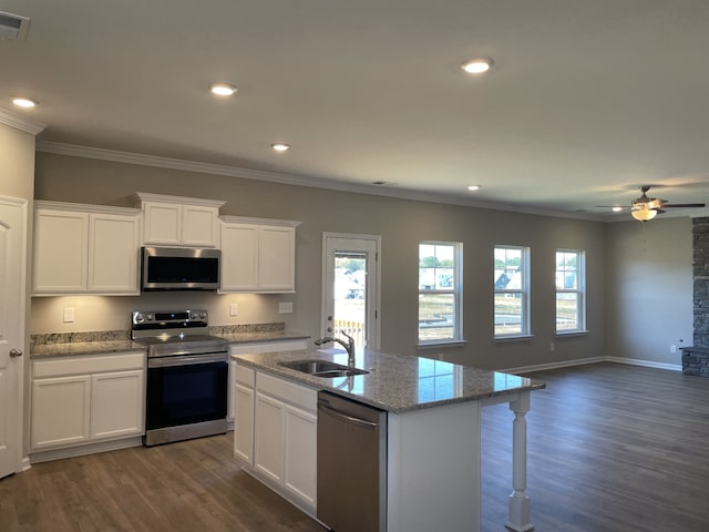 kitchen featuring an island with sink, ceiling fan, sink, appliances with stainless steel finishes, and dark wood-type flooring