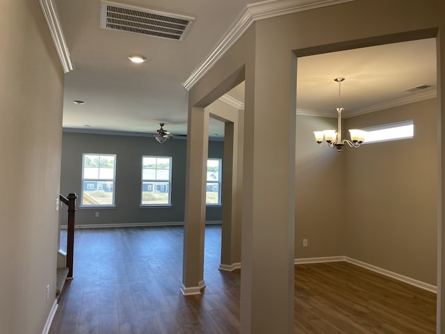 hall with a notable chandelier, ornamental molding, and dark hardwood / wood-style floors