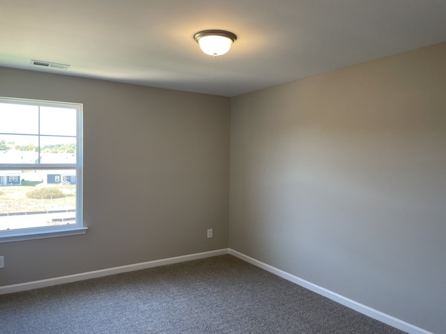 unfurnished room featuring dark carpet