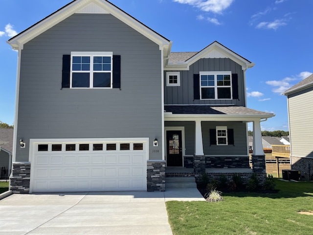 view of front of property with covered porch, a front yard, and a garage