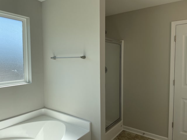 bathroom with independent shower and bath and a healthy amount of sunlight