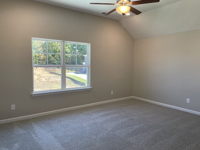 carpeted spare room featuring vaulted ceiling, ceiling fan, and a wealth of natural light