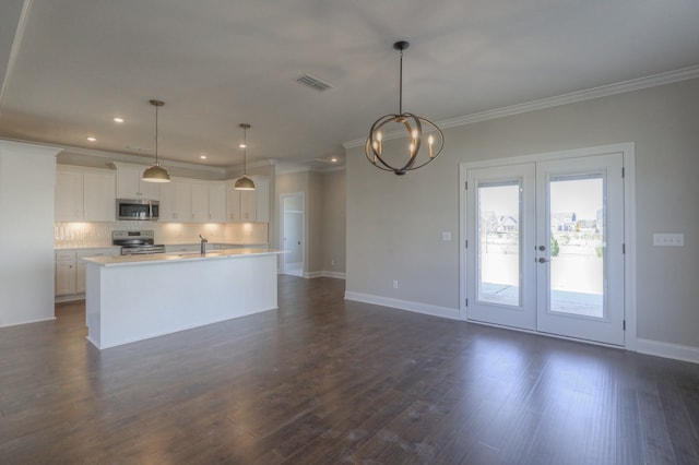 kitchen with decorative light fixtures, white cabinetry, dark wood-type flooring, stainless steel appliances, and a center island with sink