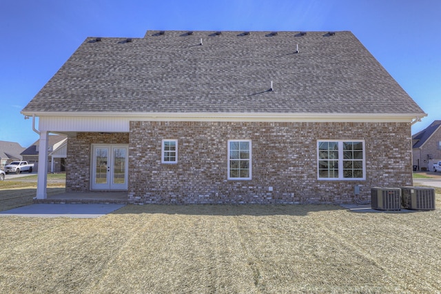 rear view of property with french doors, central AC unit, and a yard