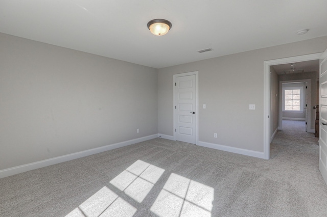 unfurnished room featuring light carpet