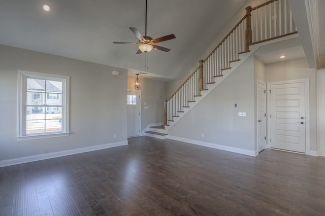 spare room featuring a high ceiling, dark hardwood / wood-style floors, and ceiling fan