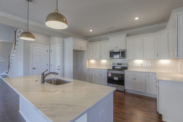 kitchen with decorative light fixtures, appliances with stainless steel finishes, white cabinets, backsplash, and sink