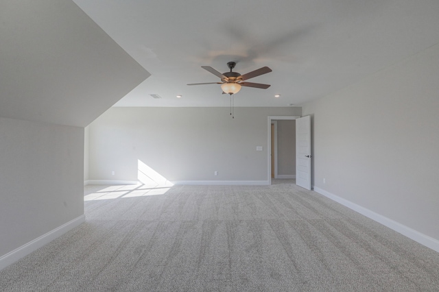 additional living space with light colored carpet and ceiling fan