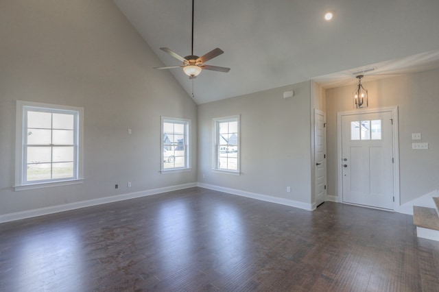 foyer with dark wood-type flooring, high vaulted ceiling, and ceiling fan with notable chandelier