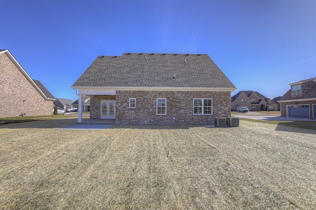 rear view of house featuring a lawn, a patio, a garage, and central air condition unit