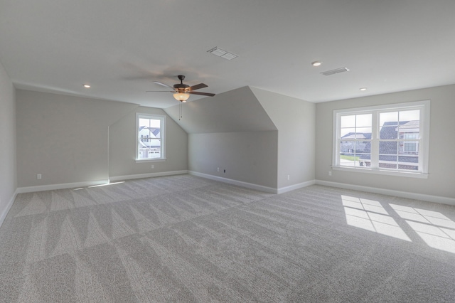 additional living space featuring light carpet, lofted ceiling, and ceiling fan