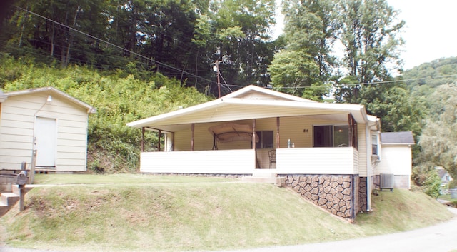 view of front facade with central air condition unit, a front lawn, and an outdoor structure