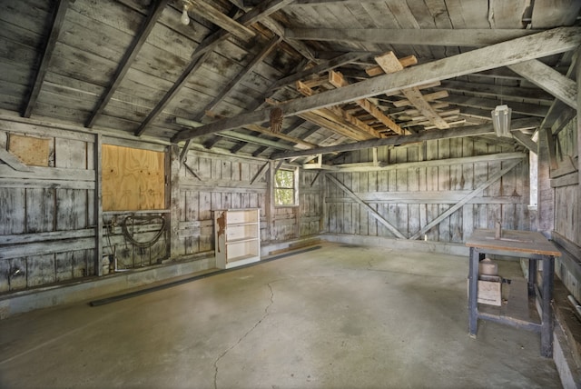 miscellaneous room featuring wooden walls and vaulted ceiling