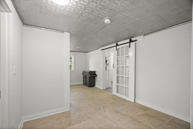 basement with a barn door and light tile floors