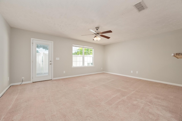 carpeted empty room featuring ceiling fan and a textured ceiling