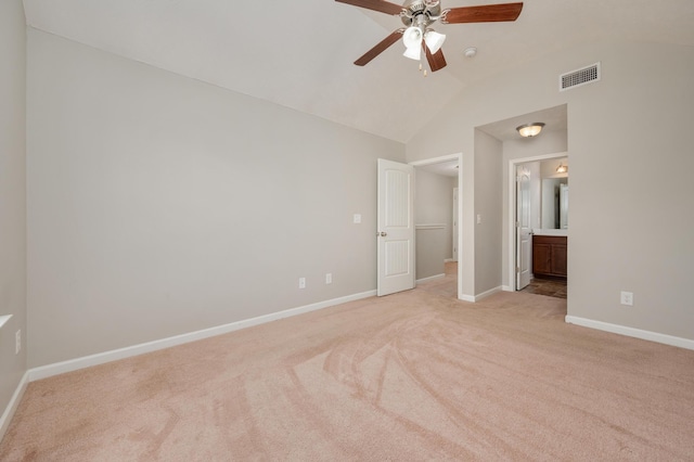 unfurnished bedroom with ceiling fan, lofted ceiling, ensuite bath, and light carpet