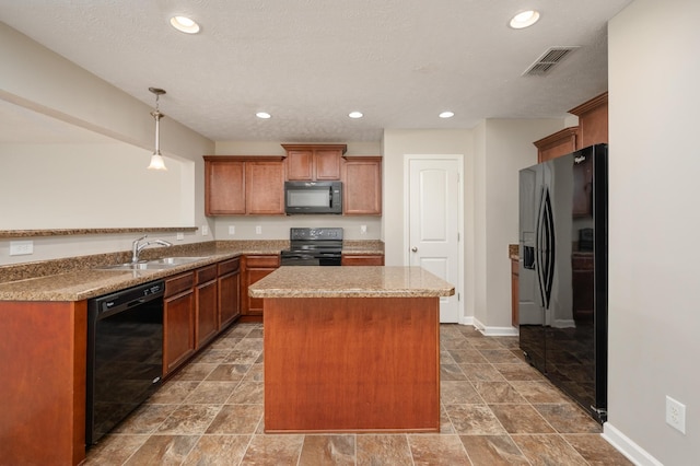 kitchen with light stone counters, black appliances, pendant lighting, dark tile flooring, and sink