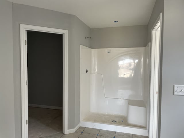 bathroom with a shower and tile floors