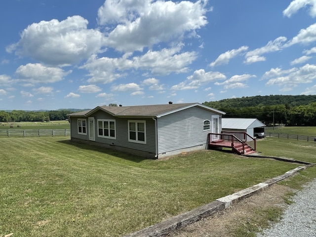 view of front of home featuring a rural view, a front yard, and a deck