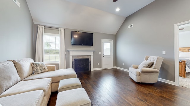 living room featuring dark hardwood / wood-style flooring, a fireplace, and high vaulted ceiling