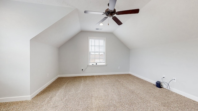 additional living space featuring light carpet, vaulted ceiling, a textured ceiling, and ceiling fan