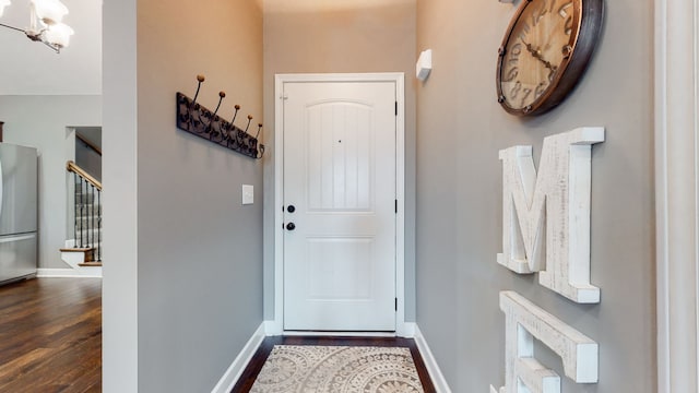 entryway with dark hardwood / wood-style flooring and an inviting chandelier