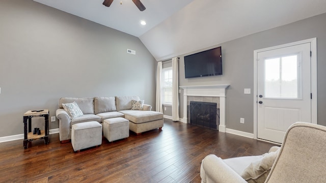 living room with dark hardwood / wood-style flooring, ceiling fan, a tile fireplace, and a healthy amount of sunlight