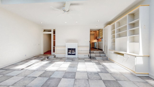 unfurnished living room featuring light tile flooring, built in features, and ceiling fan