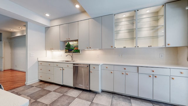 kitchen with dishwasher, sink, light tile floors, and tasteful backsplash