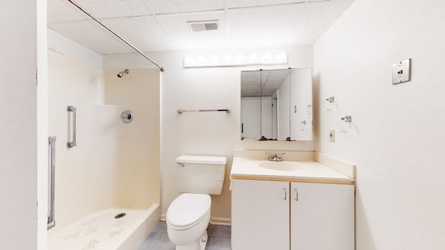 bathroom with a shower, oversized vanity, tile flooring, toilet, and a paneled ceiling