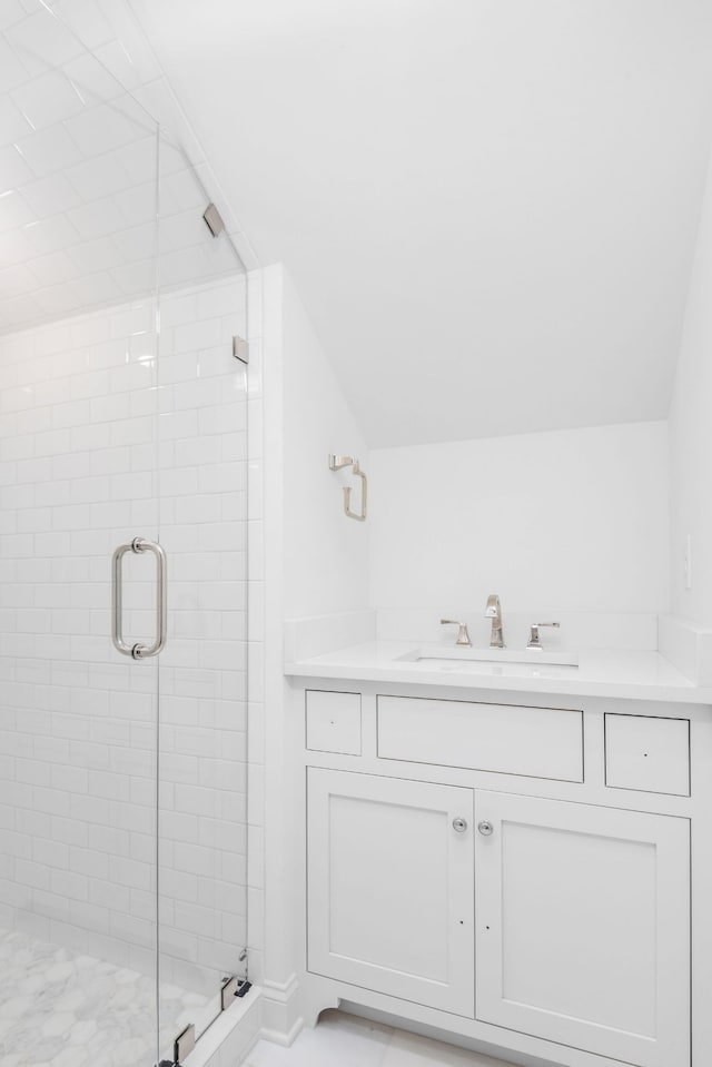 bathroom featuring walk in shower, lofted ceiling, and vanity