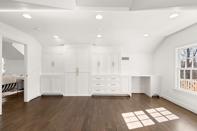 interior space with dark wood-type flooring and vaulted ceiling