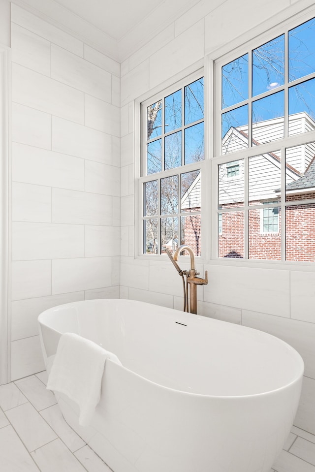 bathroom featuring plenty of natural light, tile floors, and tile walls