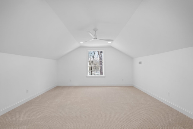 additional living space featuring ceiling fan, light colored carpet, and vaulted ceiling