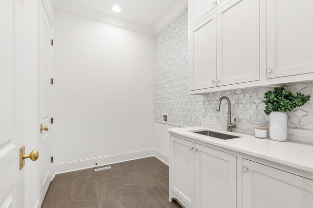 washroom featuring crown molding and sink