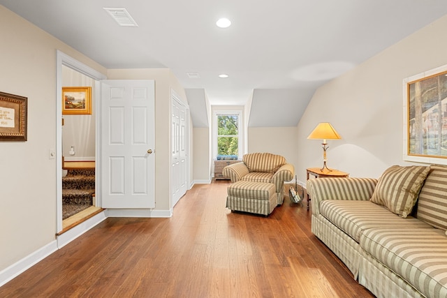 living room with light hardwood / wood-style floors and lofted ceiling