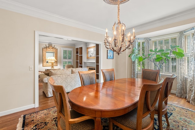 dining area featuring crown molding, a notable chandelier, and light hardwood / wood-style floors