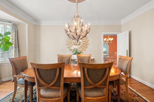 dining room featuring a chandelier, light hardwood / wood-style flooring, and crown molding