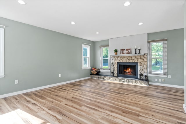 unfurnished living room featuring a fireplace and light hardwood / wood-style flooring