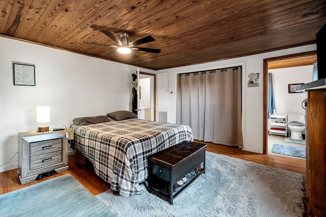 bedroom featuring ceiling fan, wooden ceiling, dark wood-type flooring, and connected bathroom