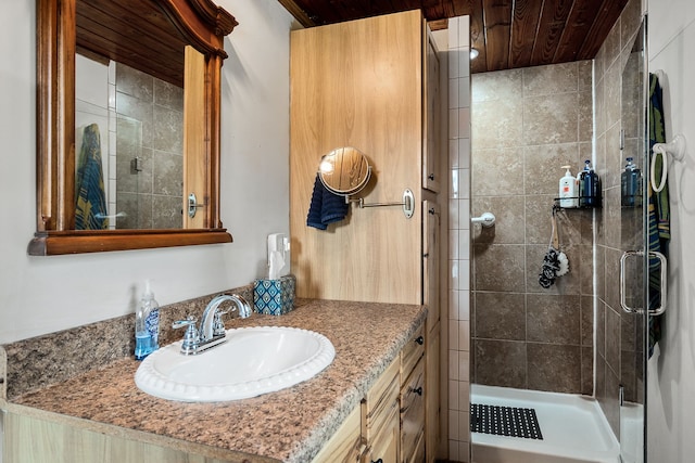 bathroom with wooden ceiling, a shower with shower door, and vanity with extensive cabinet space