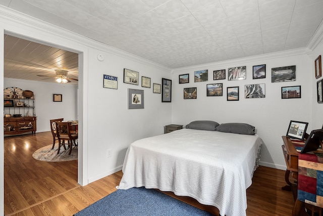 bedroom with crown molding, ceiling fan, and dark hardwood / wood-style floors