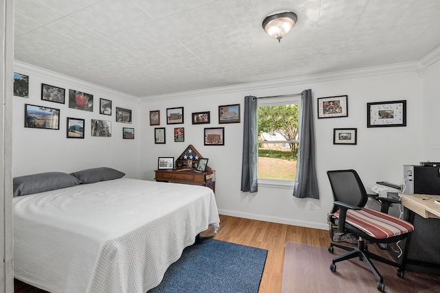 bedroom featuring ornamental molding and light wood-type flooring