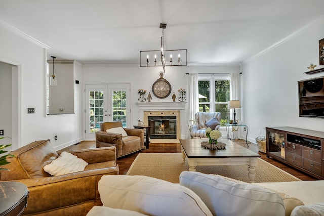 living room with dark hardwood / wood-style flooring, a notable chandelier, ornamental molding, and french doors