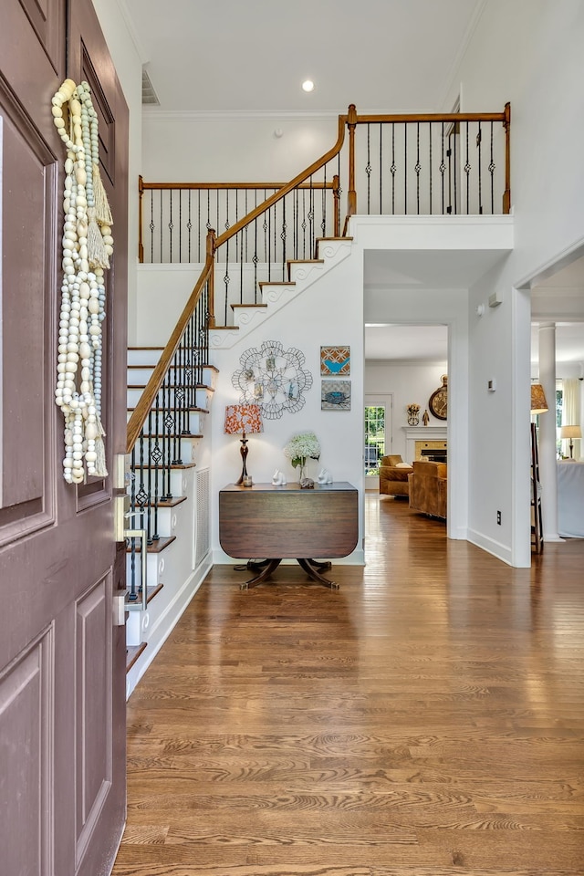 foyer entrance with ornamental molding and hardwood / wood-style flooring