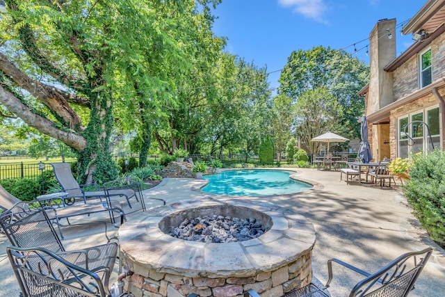 view of swimming pool with a patio area and a fire pit